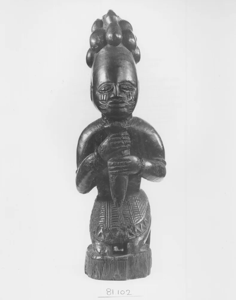 Eshu-Elegba — figur-berlutut Yoruba dari Nigeria, kayu dengan kerang-cowrie dan bahan-tradisional; koleksi Brooklyn Museum 81.102 (abad XIX-XX)